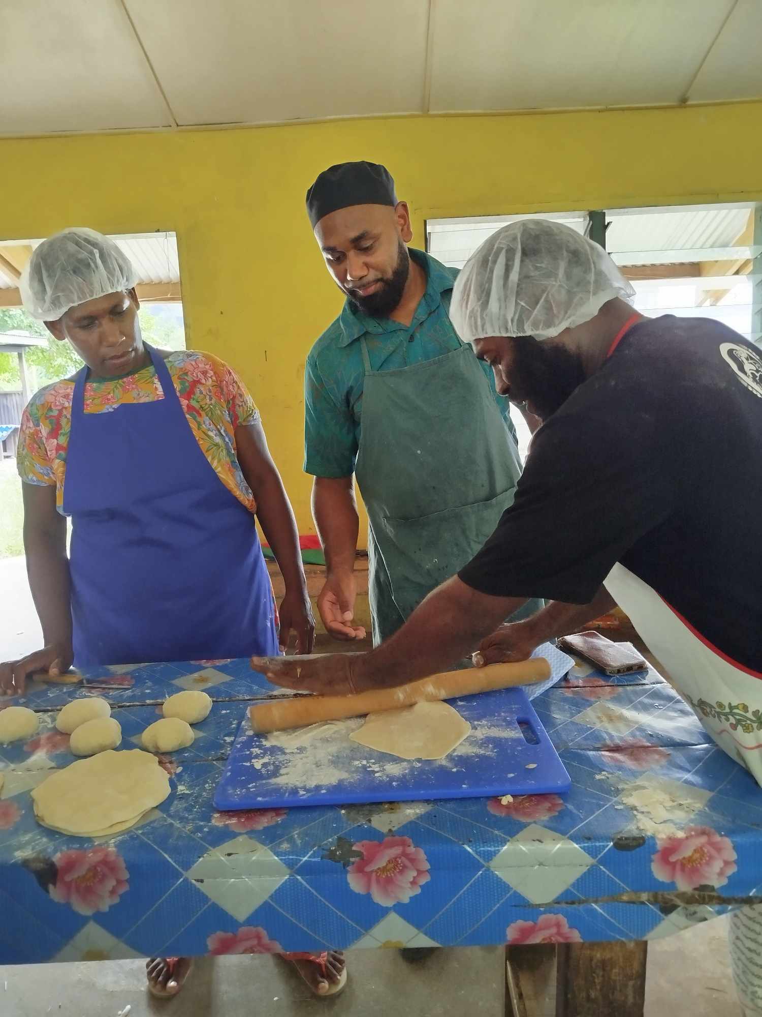 Photo 3 - Trainer Knox guides participants on the proper technique for rolling pizza dough